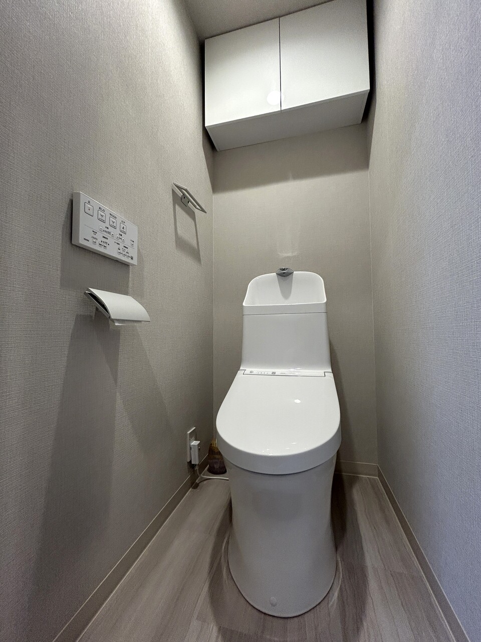 【トイレ】白を基調とした清潔感のあるトイレです。背面に収納棚が設置されているので、トイレットペーパーや掃除用具などを収納できます。
