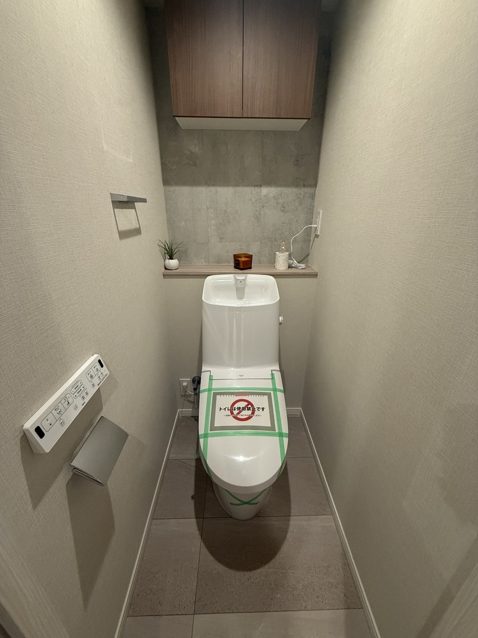 【トイレ】ホワイトを基調としたシンプルな内装です。上部には棚が設置されており、トイレットペーパーや掃除用具などをまとめて収納可能です。