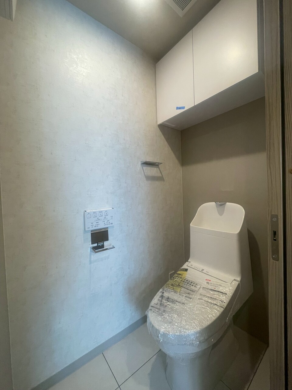 【トイレ】清潔に利用できる温水洗浄機能付きトイレです。上部には収納棚を設置しています。トイレットペーパーや掃除用品を収納することができます。