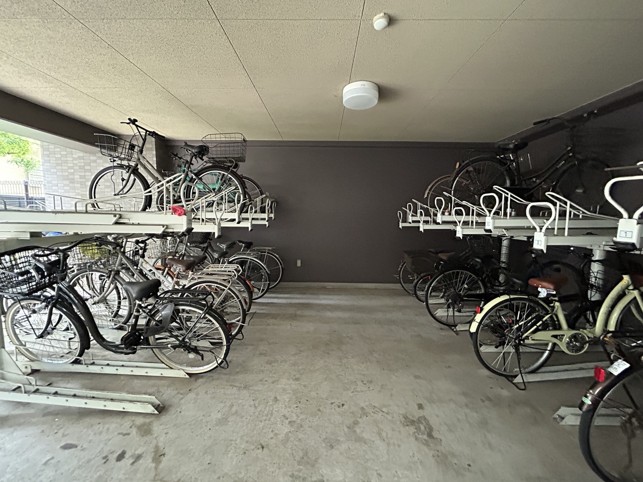 【駐輪場】雨風の影響を受けにくい、屋内型の駐輪場です。2段式のサイクルラックが備わっています。空き状況・利用料など、お気軽にお問い合わせください。