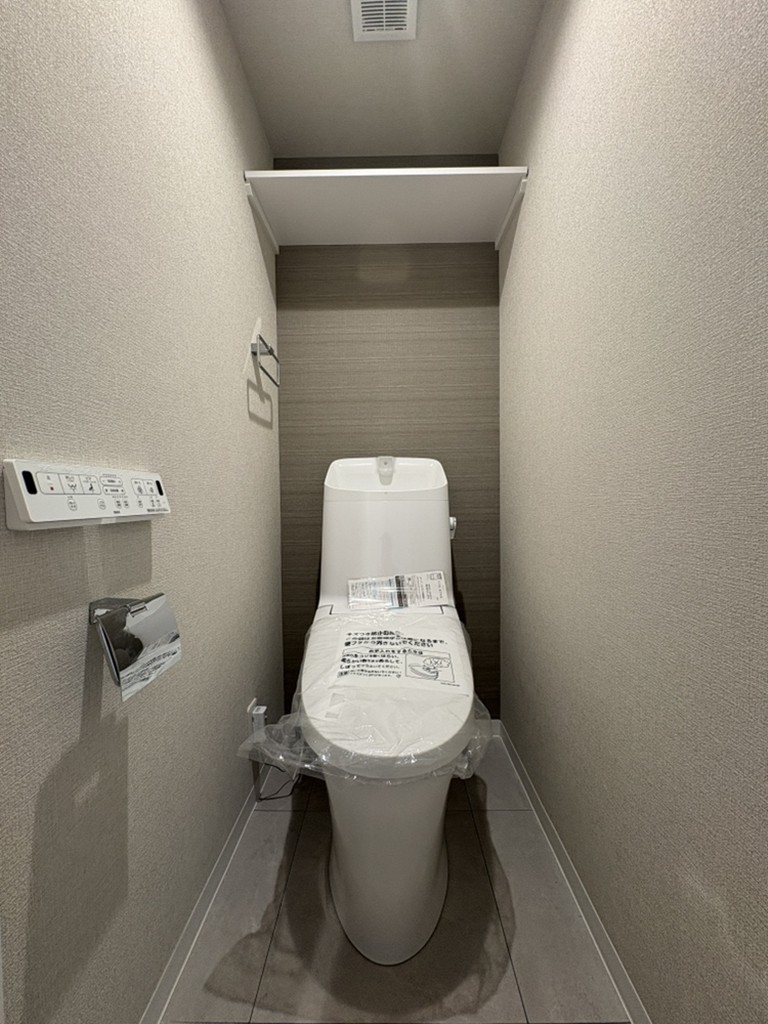 【トイレ】温水洗浄便座付きトイレが採用されています。清潔に使用することができ衛生的です。上部に棚があり、トイレットペーパーや掃除用品を置くことができます。
