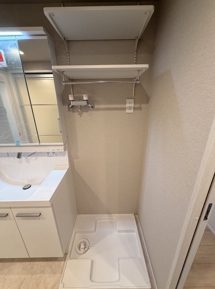 【洗面室】洗濯機置場の上部には棚が設けられており、タオルや洗濯用品などをすっきり収納できます。設置可能な洗濯機のサイズなどは、現地にてお確かめください。