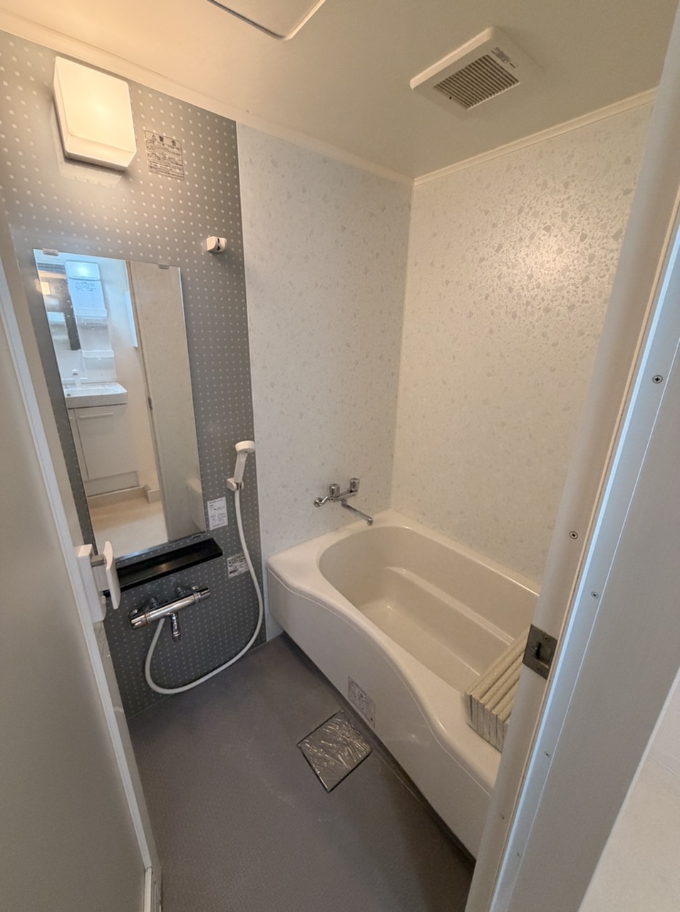 【浴室】淡い色味でまとめられ、1日の疲れをゆっくりと癒していただける浴室です。縦長の鏡や小物を置けるカウンターが備わり、使い勝手に配慮されています。