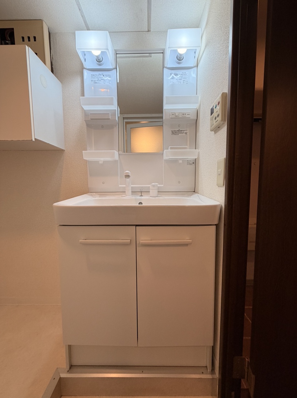 【洗面所】白を基調とした清潔感のある洗面化粧台です。鏡横・洗面ボウル下に収納スペースが備わっており、洗面用品や化粧品、ストック類などを整理できます。