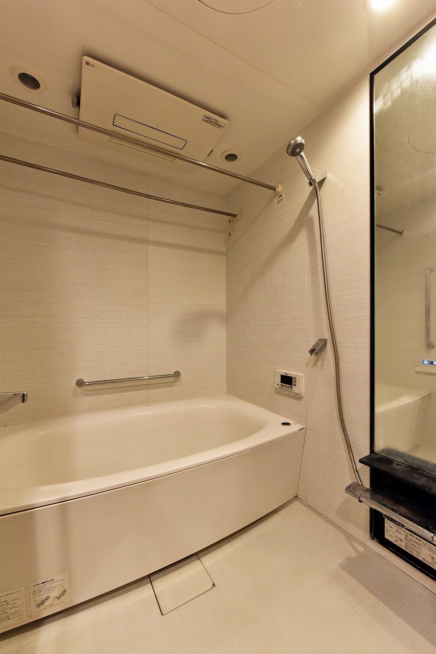 【浴室】白を基調とした清潔感あふれるバスルーム。浴槽近くに立ち上がりをサポートする手すりが備わっています。