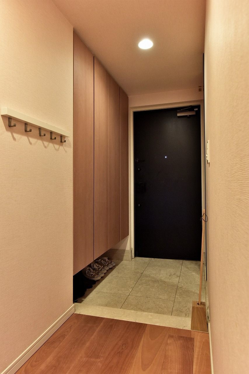 【玄関】温かみのある木目調のフローリングが続く廊下。壁面にはコートや帽子、鍵などの保管に便利なフックが備わっています。廊下から各洋室へ直接アクセスできる、プライバシーにも配慮された間取りです。