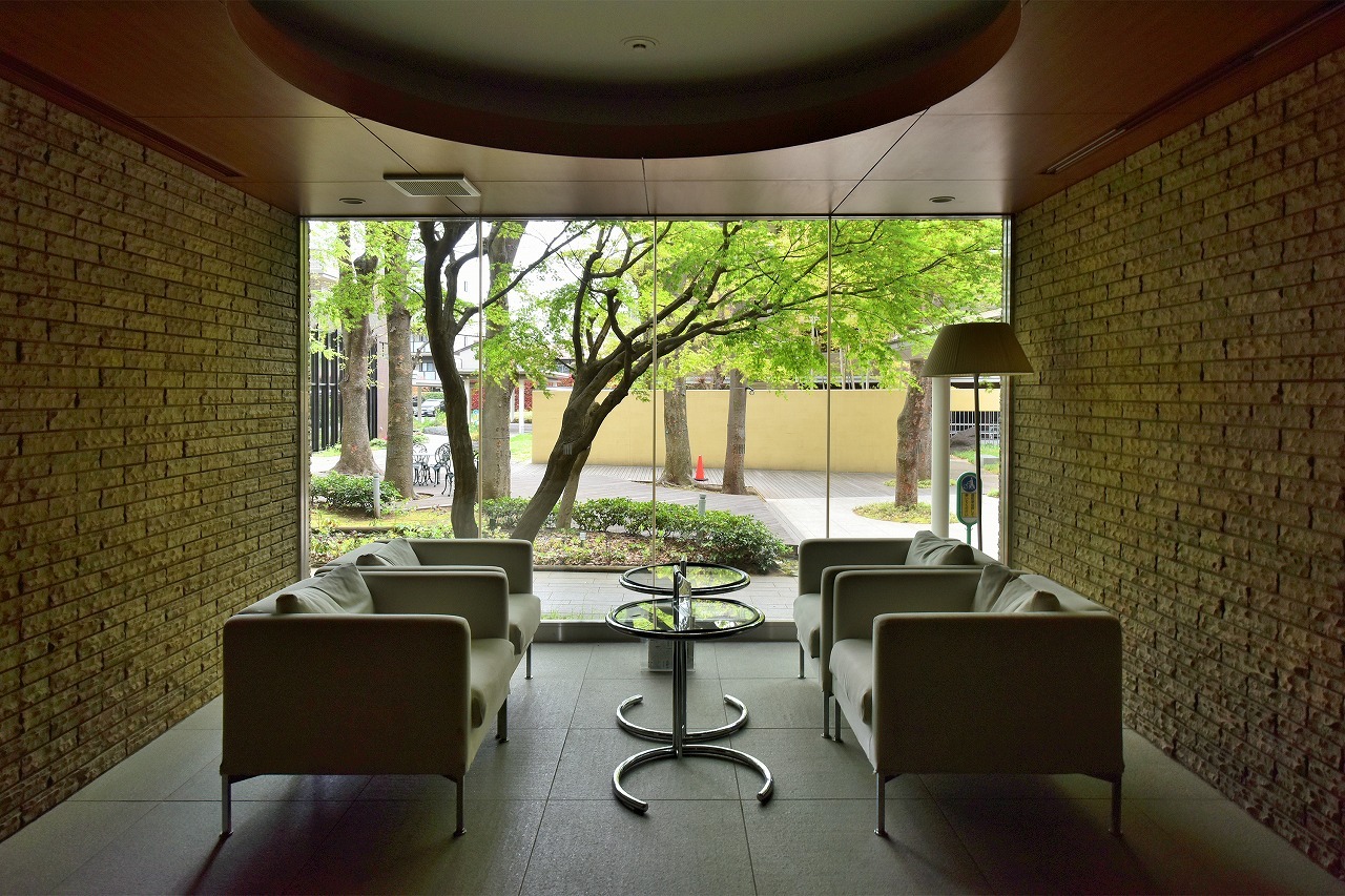 【エントランス】ソファーやテーブルが設置されており、ゲストとの待ち合わせや歓談のスペースとしても利用可能。大きな窓から外の景色も楽しめる明るい空間です。