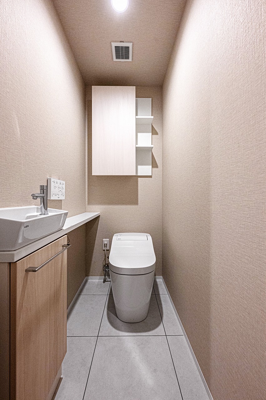 【トイレ】清潔に利用できる温水洗浄機能付きトイレです。上部と手洗い下に収納があり、トイレットペーパーや掃除用品を収納することができます。