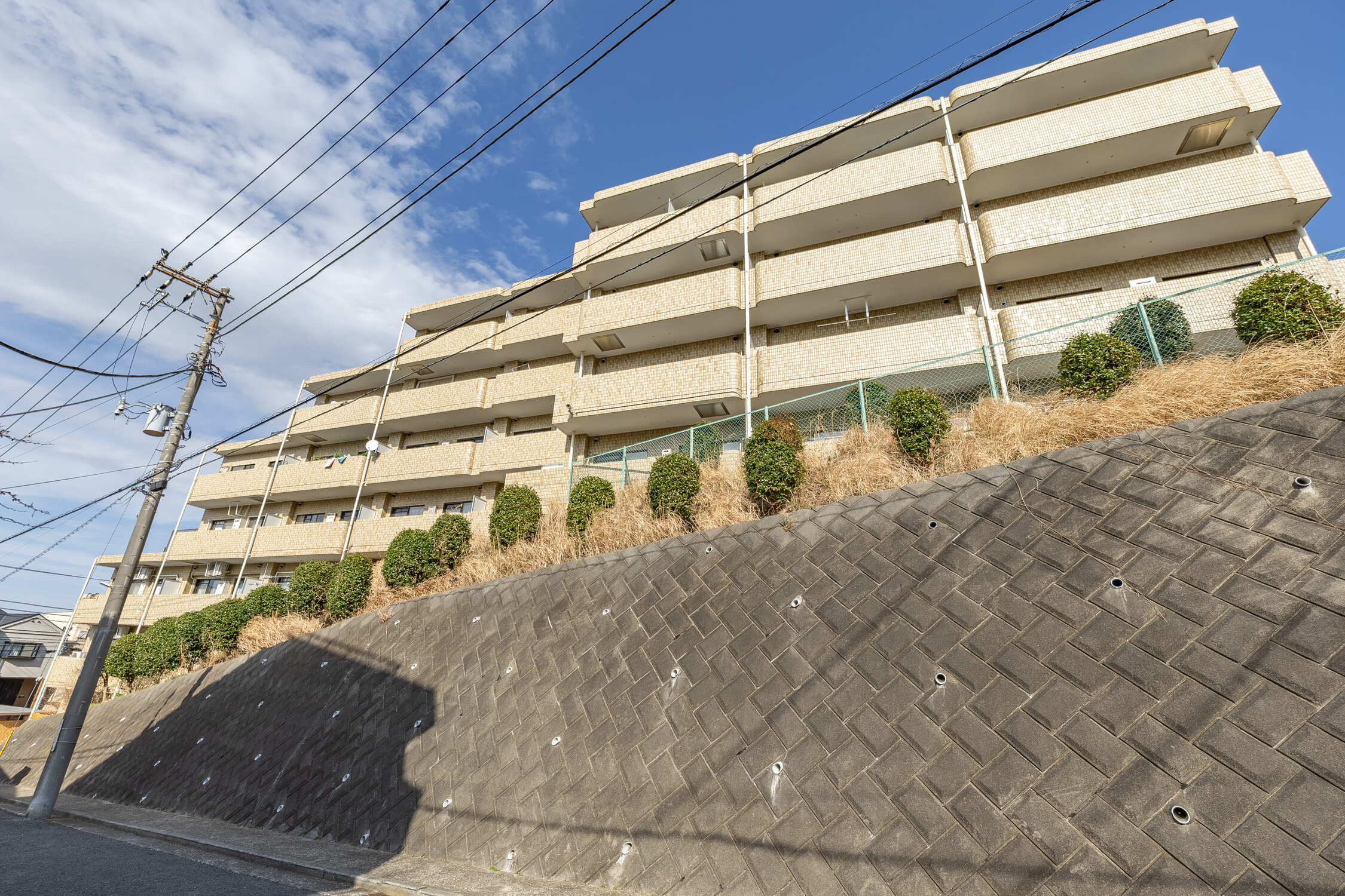 【現地外観写真】周辺道路との高低差があり、植栽や擁壁などでプライバシーを確保した造り。徒歩12分圏内で3駅利用可能な利便性の高さも魅力です。
