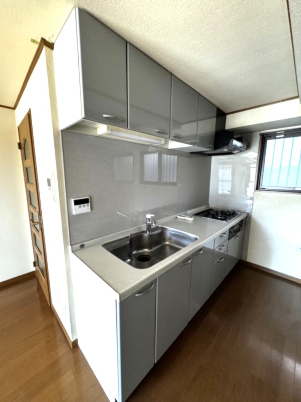 壁付けのキッチン。料理中の水はねや汚れもさっと拭き取れ手入れが簡単です。吊戸棚付きです！