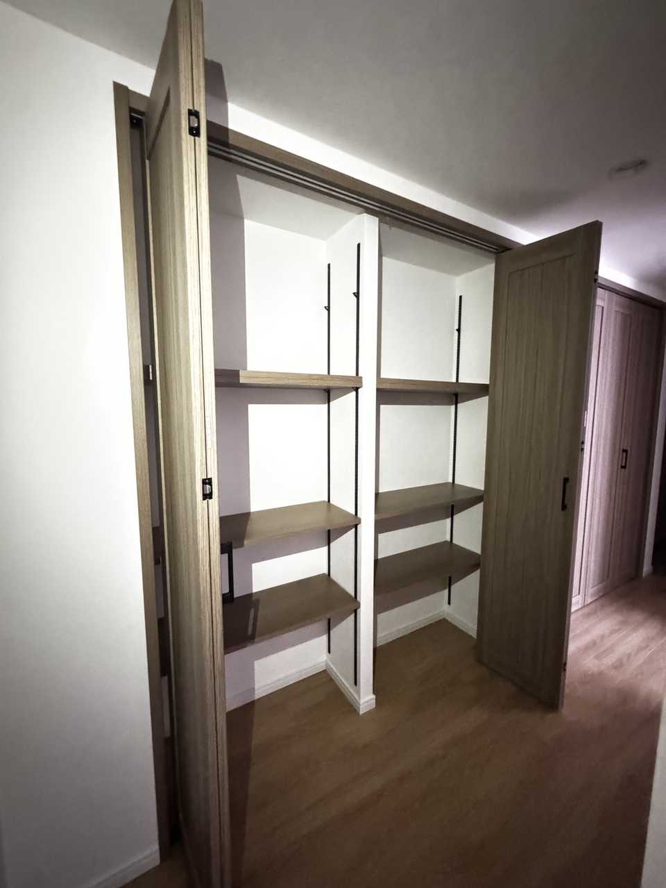 【廊下収納】食料品や日用品のストック収納、季節外の履物の保管場所としてなど、多目的に活用可能です。棚板は可動式のため、用途に合わせて高さを調節できます。