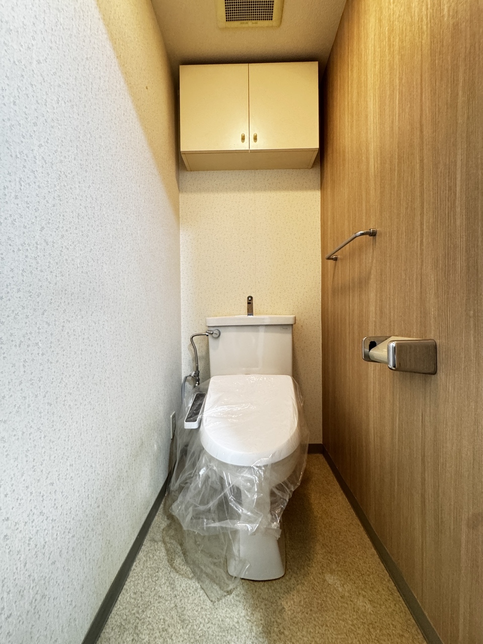 【トイレ】温水洗浄便座付きのトイレです。寒い時期でも温かな便座で快適に使うことができます。トイレットペーパーや掃除用具などの保管に便利な吊り戸棚が設置されています。