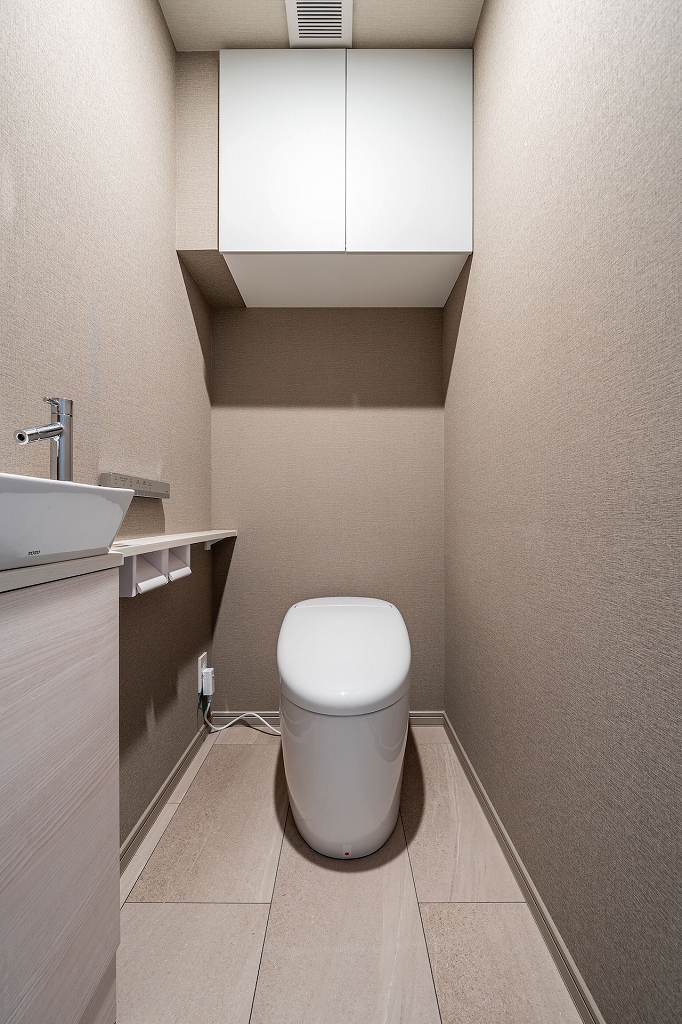 【トイレ】スタイリッシュなデザインが魅力的な、温水洗浄便座付きのトイレです。独立した手洗い器を設置しているため、使用後すぐに手洗いができます。