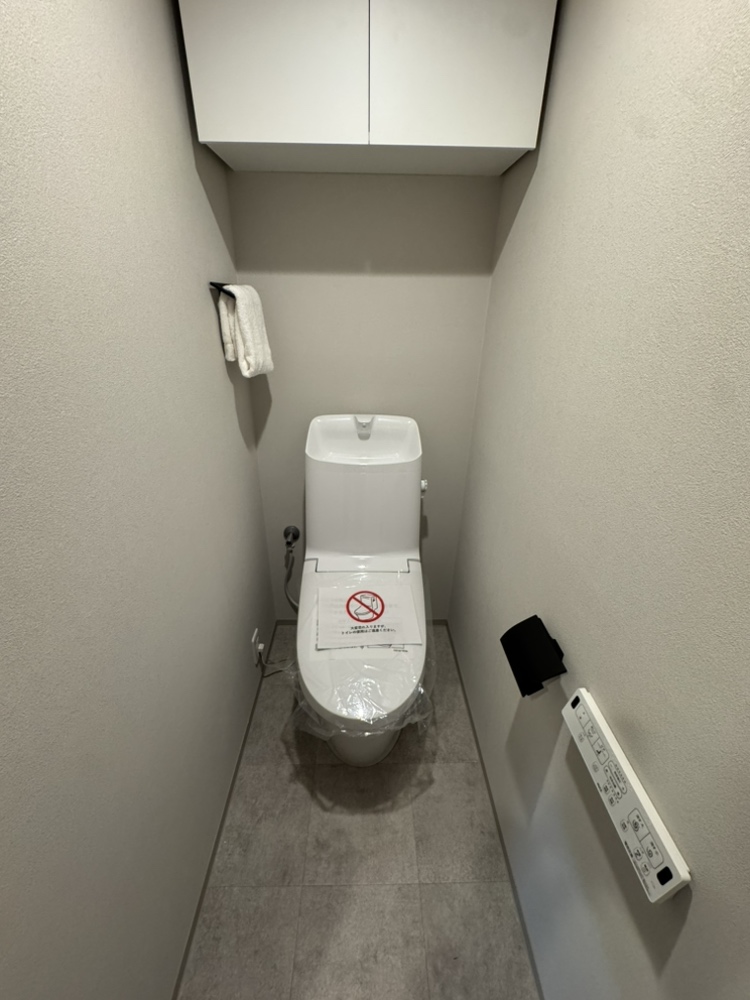【トイレ】シックな雰囲気で落ち着きのあるトイレです。年中快適に利用できる、温水洗浄便座付き。壁付けリモコンが設置されているので、操作がしやすいです。