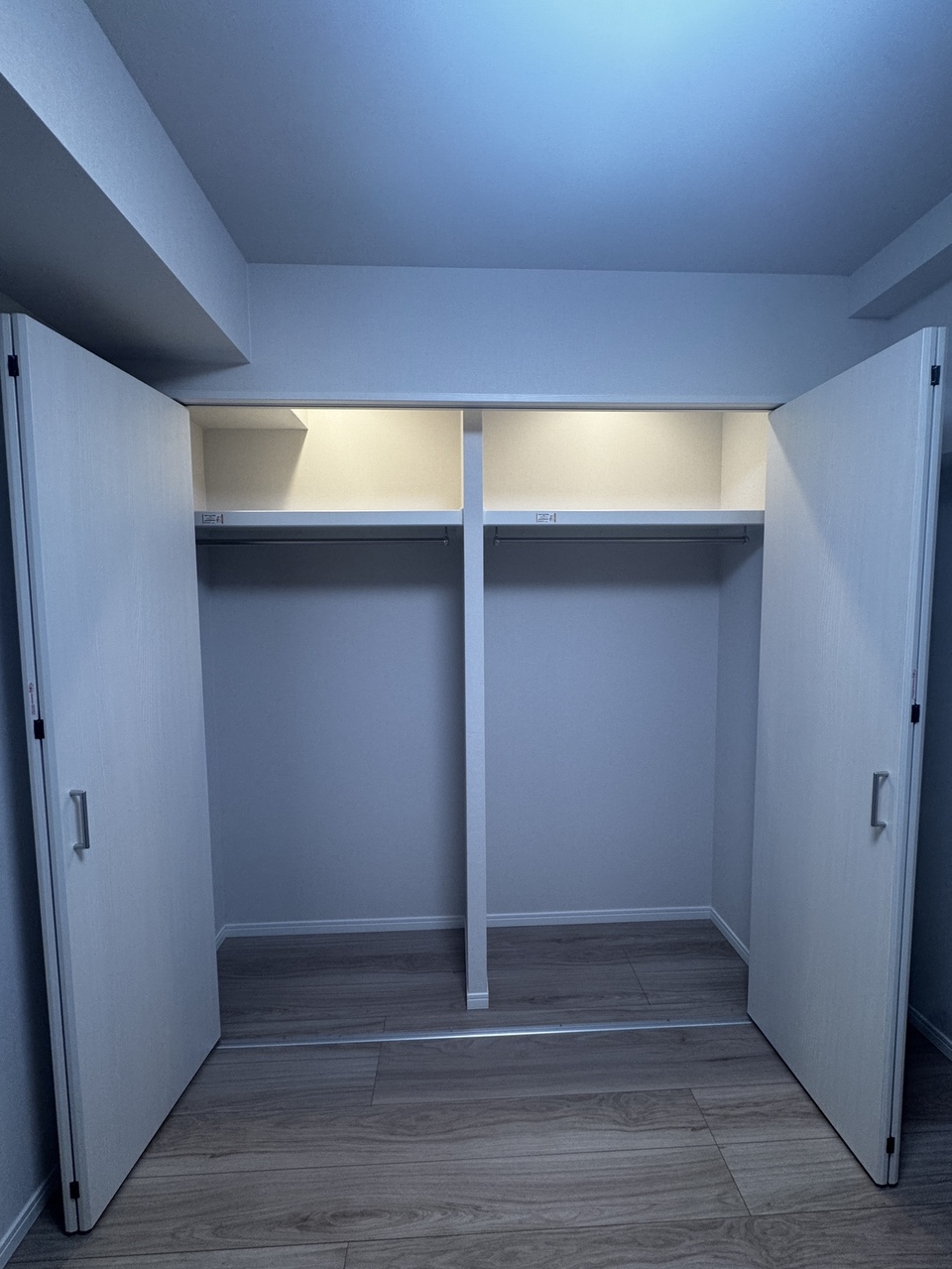 【収納/洋室約4.9帖】両開き戸のため、目当ての衣類が探しやすそうです。クローゼット内に照明、枕棚、ハンガーパイプが設置されています。