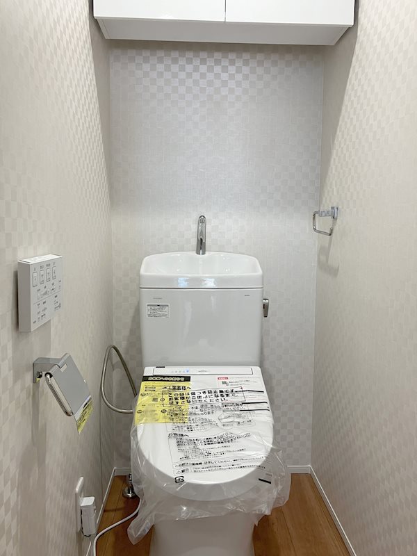 【トイレ】ペーパ類がまとめて収納できる上吊り戸棚付き。