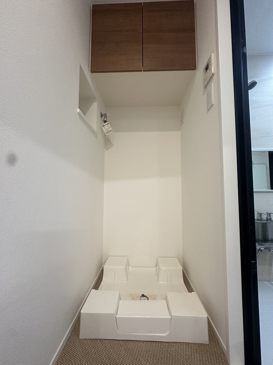 【洗濯機置場】洗面室に洗濯機置場が備わっています。上部に扉付きの収納棚が設置されています。洗剤やタオルを整理することができます。