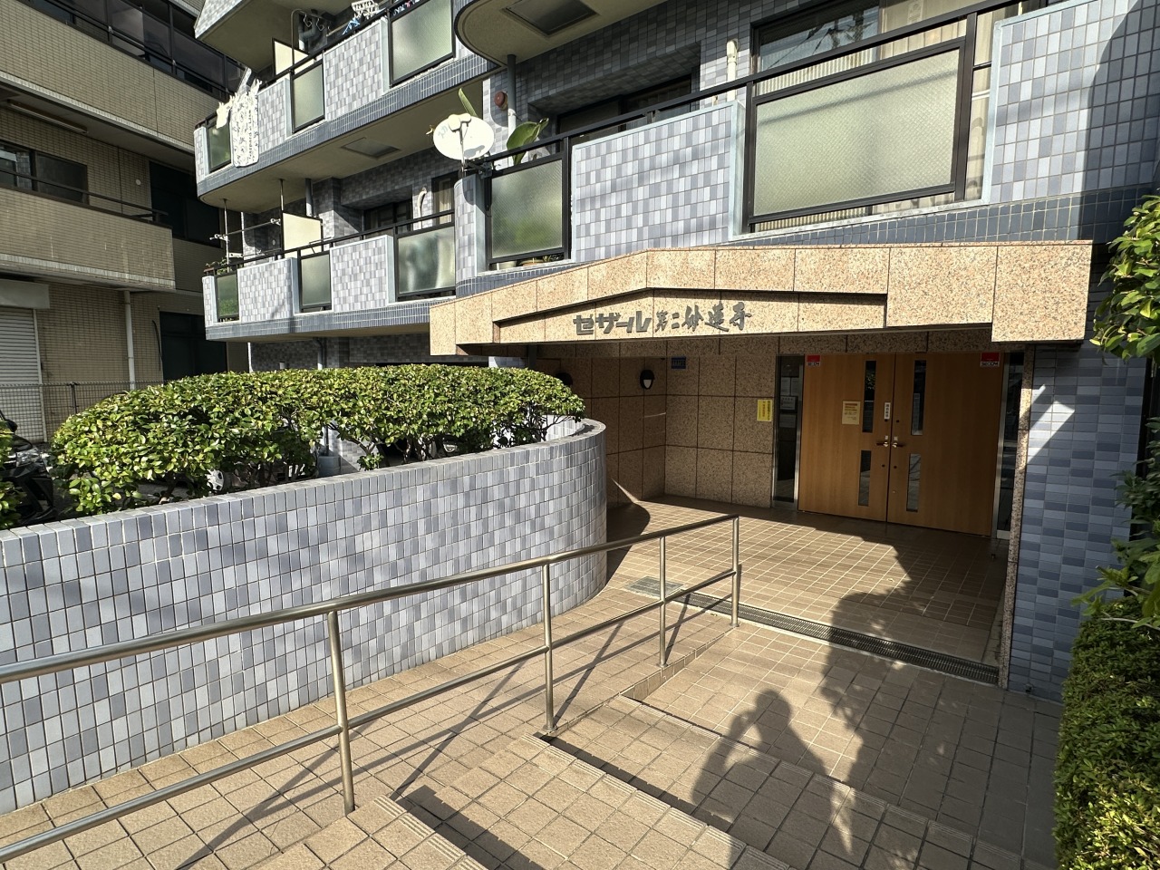 緩やかなスロープを設けたバリアフリー仕様のアプローチ。植栽が爽やかに住む人を迎えます。