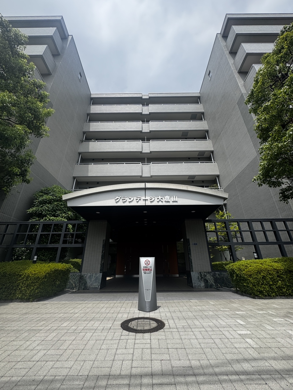 【エントランス】エントランス入口には屋根がありますので、雨の日も慌てずに傘をさすことができます。植栽があり、外部からマンション内が見えにくくなっています。