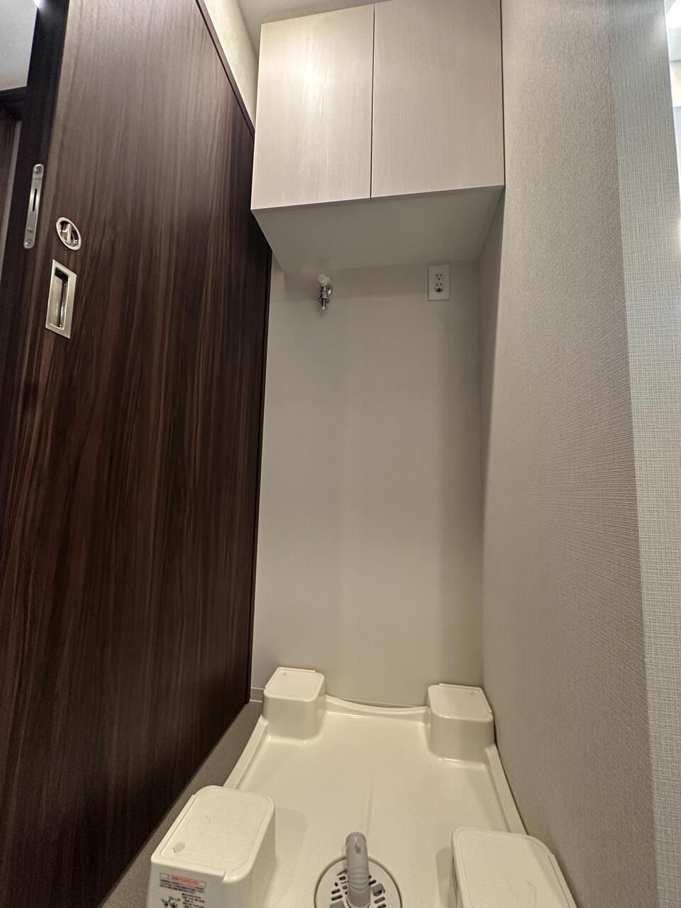【洗面室】洗面室に設けられた洗濯機置き場。設置可能なサイズは現地でご確認ください。上部には収納スペースが設置されています。
