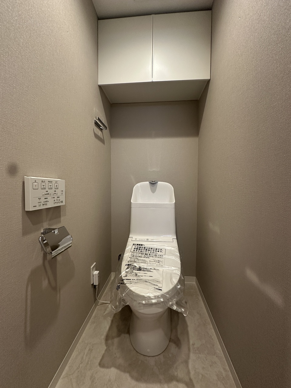 【トイレ】上部に扉付きの収納棚が有り、トイレットペーパーや掃除用具等を、すっきりとしまうことができます。リモコンが壁に設置され、操作しやすい仕様です。