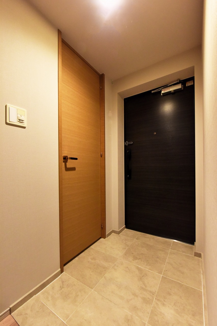 上質感漂うタイル床とシックな建具が迎える玄関アプローチ。玄関横には便利なシューズインクローク付き。