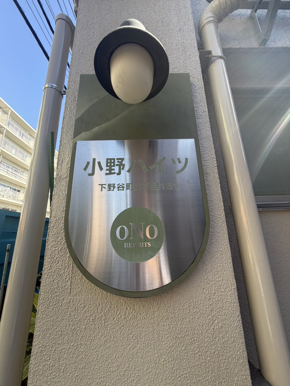 【館銘板】マンション名と住所が記載された館銘板が設置されています。1977年10月築、RC造5階建てのマンションです。総戸数は30戸です。