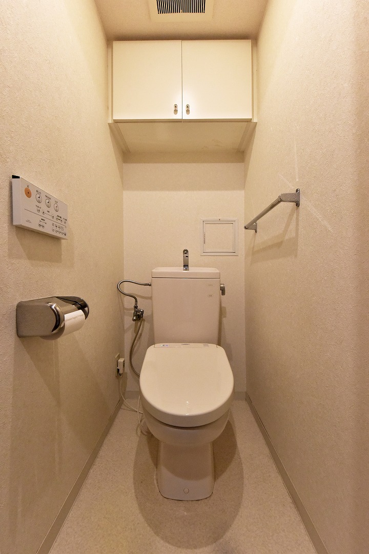 【トイレ】年間を通して、快適に使うことができる温水洗浄便座付きのトイレ。リモコンは操作しやすい壁付けタイプです。上部には収納が設けられています。
