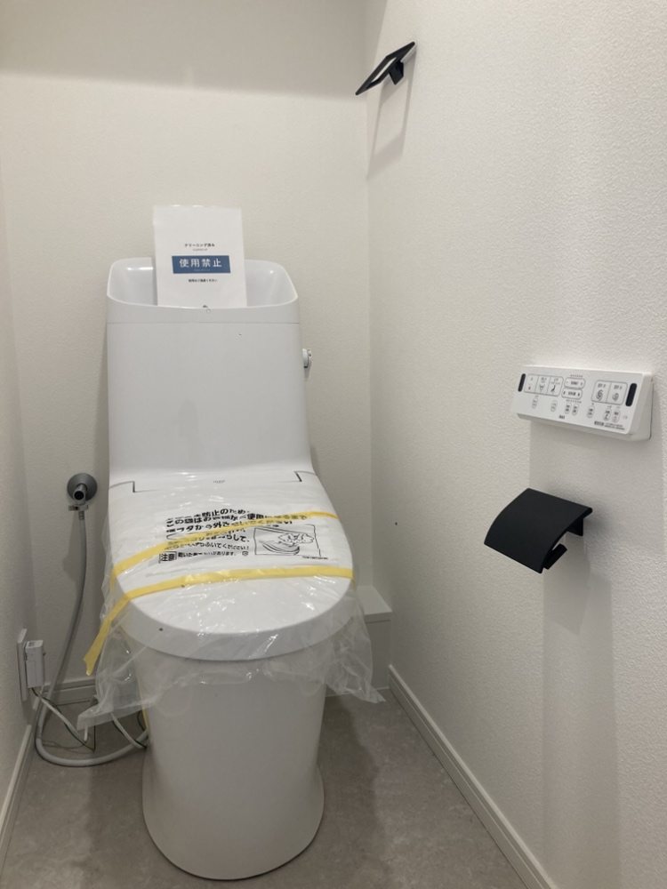 【トイレ】リモコンが壁に設置されているため、座ったままでもスムーズに操作ができます。シンプルなデザインで、日々のお手入れがしやすそうです。
