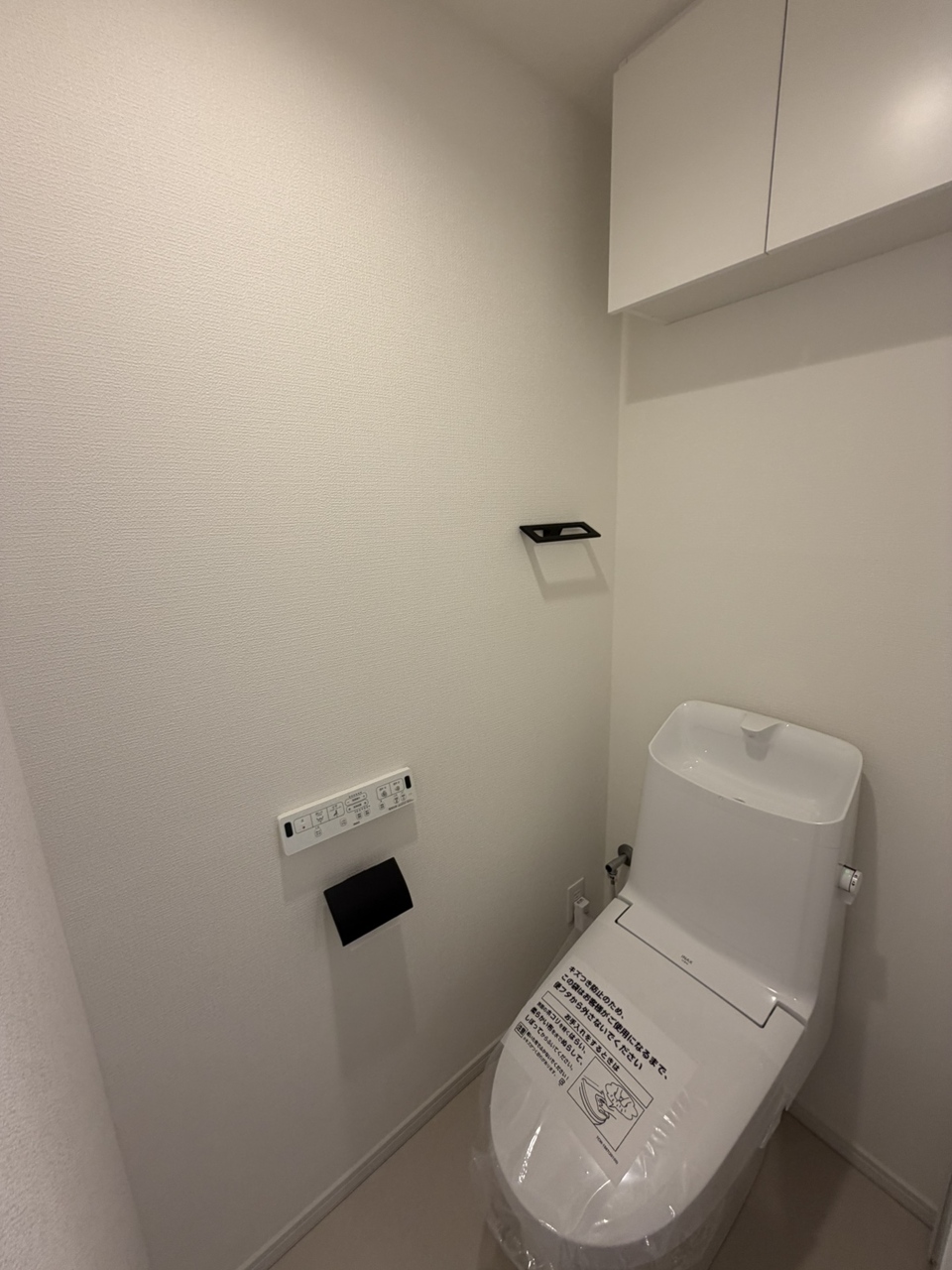 【トイレ】毎日快適に使える、温水洗浄便座付きです。操作がしやすい、壁付けリモコンが設置されています。トイレットペーパーのストック置きに便利な収納付きです。