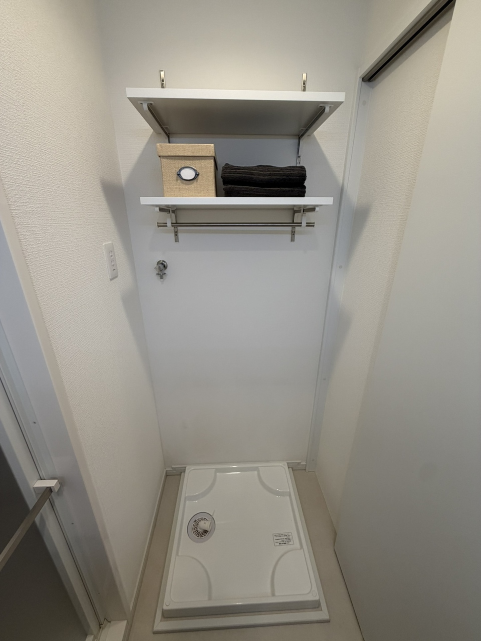 【洗面室】洗濯機置き場として洗濯パンが設置されています。上部には可動棚が付いているため、洗剤などを収納できます。