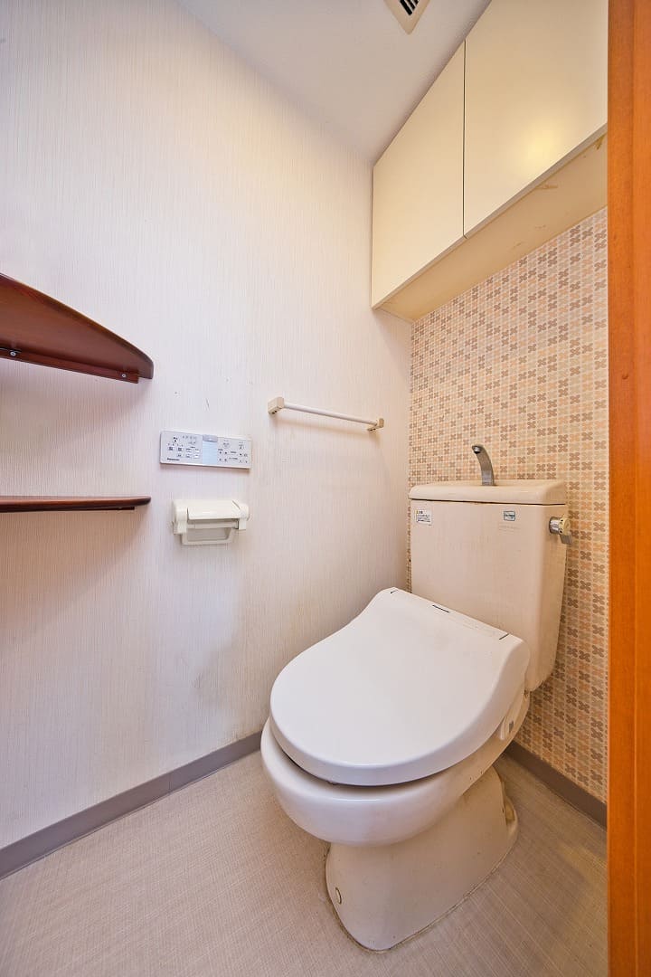 【トイレ】アクセントクロスが施された明るい印象のトイレ。上部に吊り戸棚があり、トイレットペーパーのストックや掃除用具・衛生用品などの収納に重宝します。