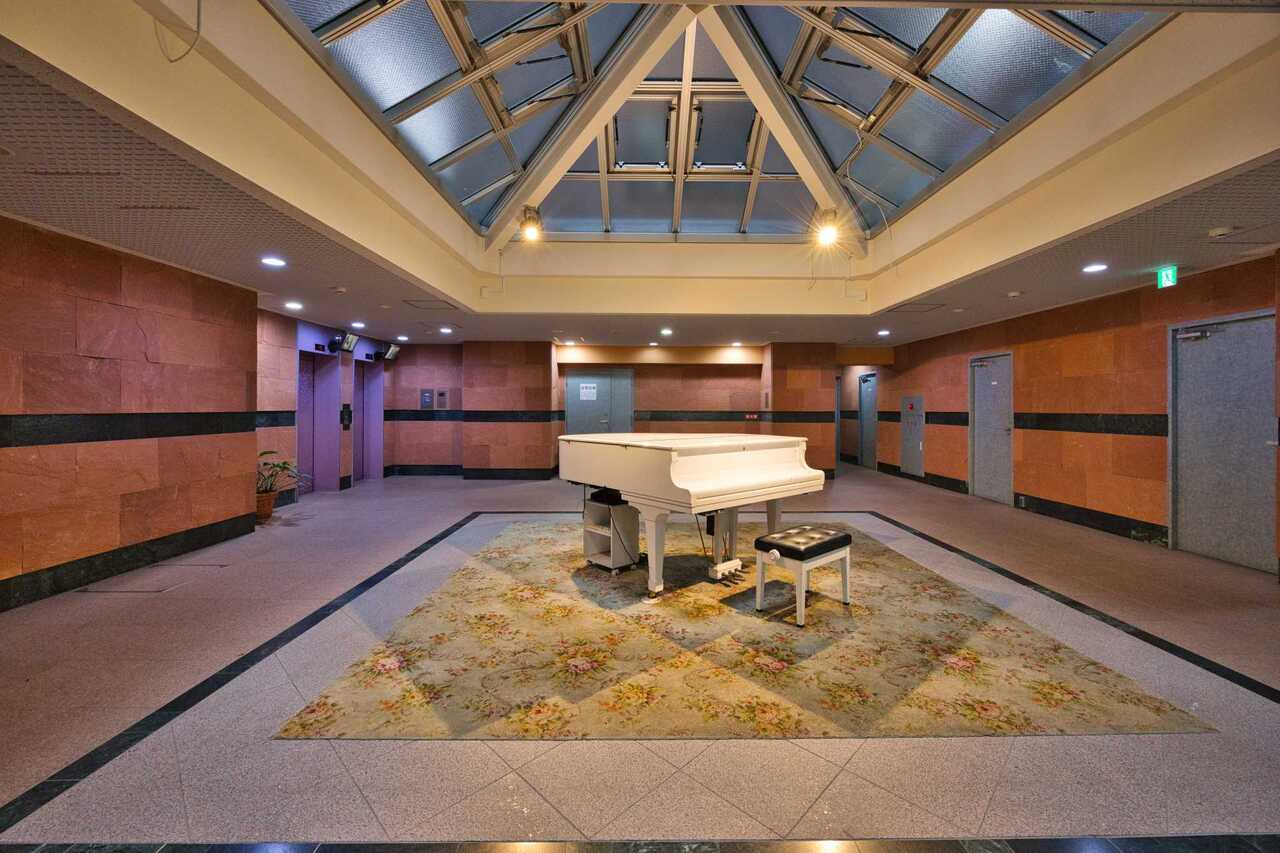 【ロビー】グランドピアノが出迎えてくれる、ホテルライクなロビー。ゲストを招きたくなる空間です。エレベーターが複数台設置されています。
