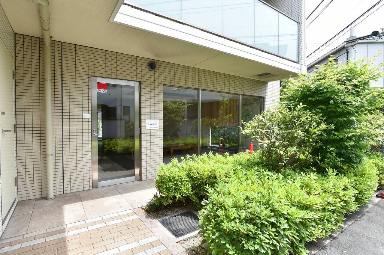 【共用部】爽やかな陽光が降り注ぎ、ロビーまで光を届けてくれています。緑豊かな植栽から、毎日自然を感じることができる空間です。