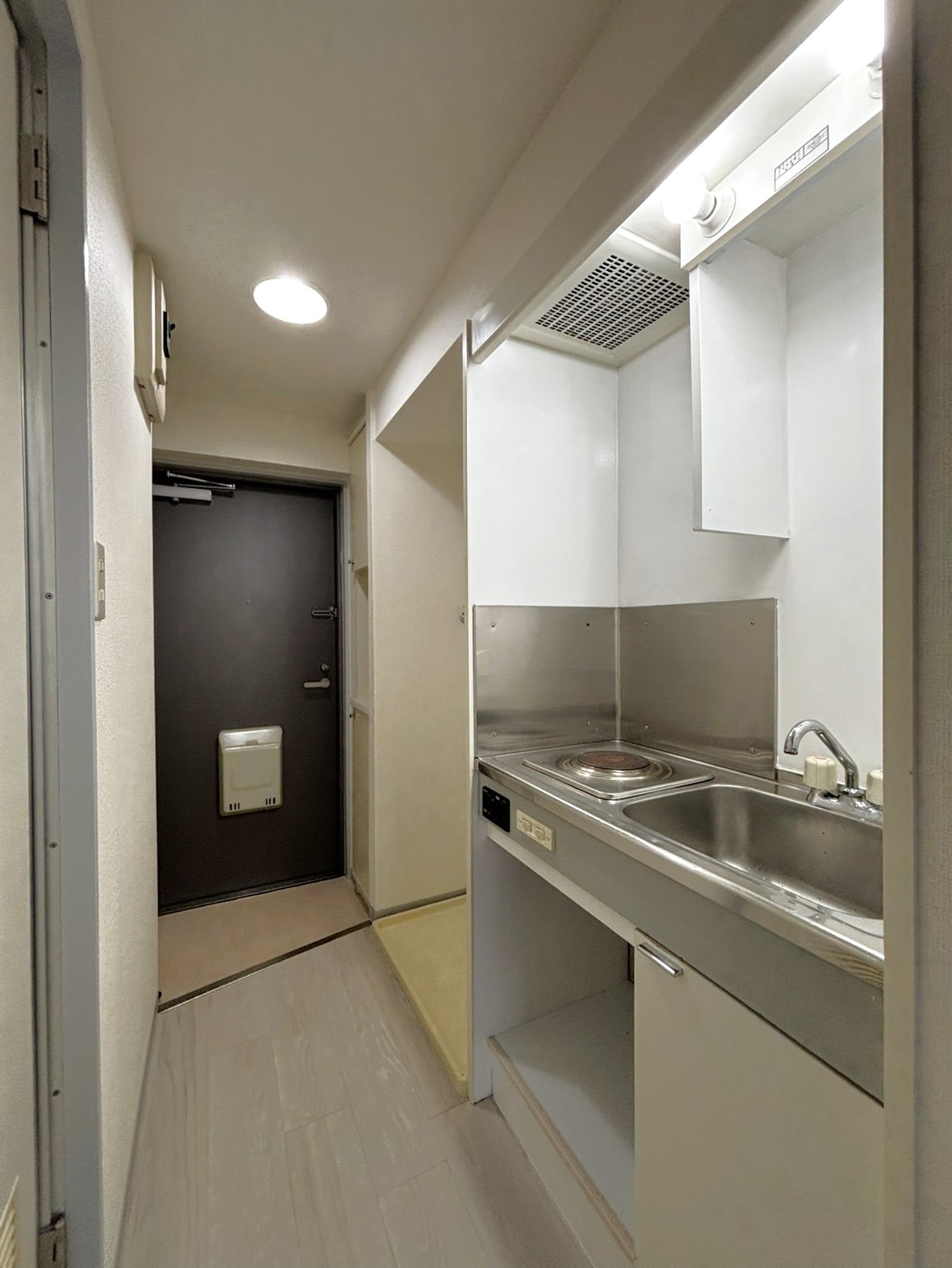 【キッチン】電気コンロが設置されたキッチンです。土鍋やアルミ鍋など金属の種類に関係なく調理器具を使用することができます。下部に収納スペースがあります。