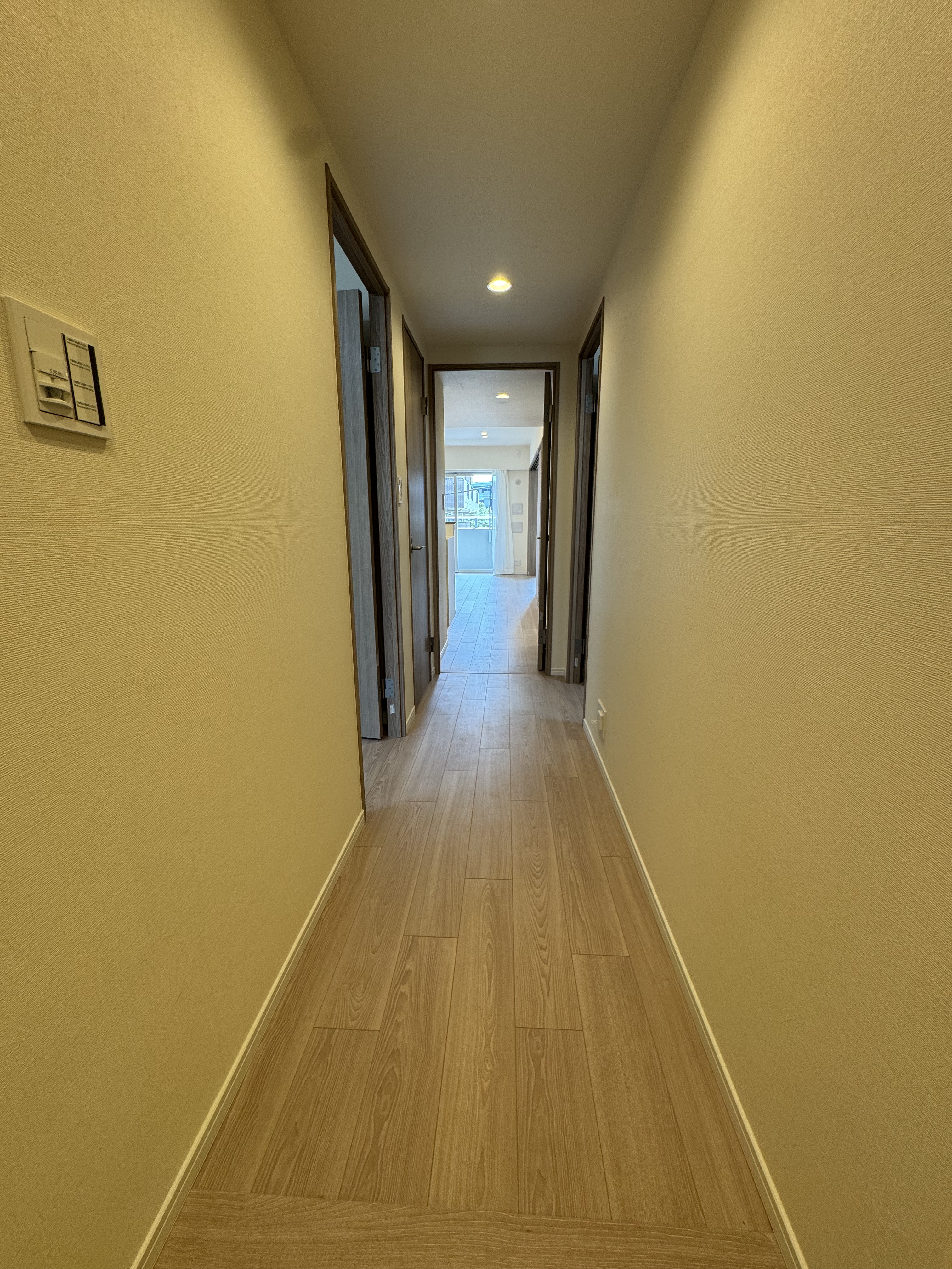 【廊下】玄関からLDKへまっすぐに伸びる廊下です。暖かい色味のダウンライトが、落ち着きのある空間を演出しています。