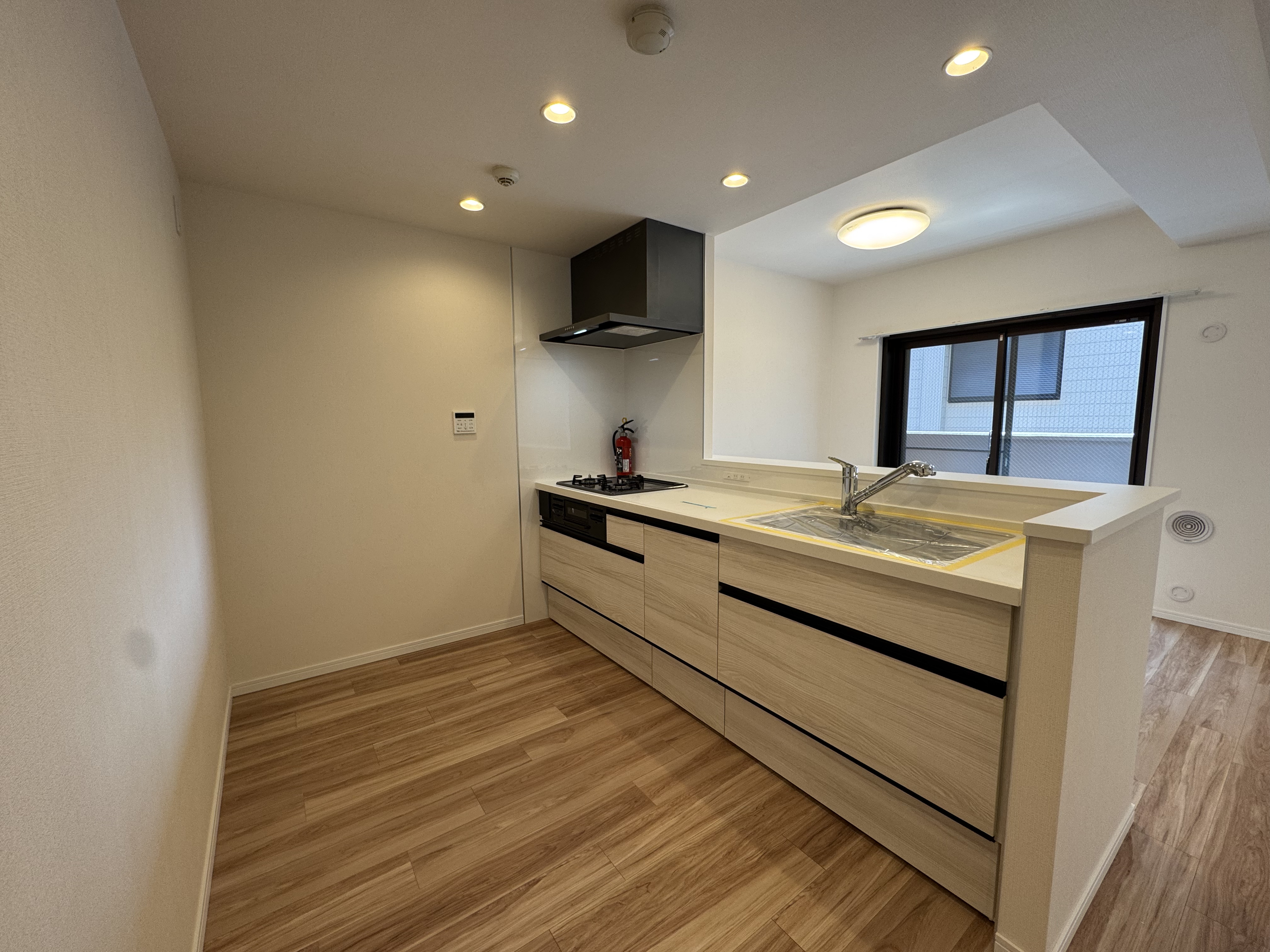 【キッチン】落ち着いた木目調で、使うたびに愛着が湧きそうなシステムキッチン。浄水器一体型水栓が設置されています。/2026年3月システムキッチン交換済み