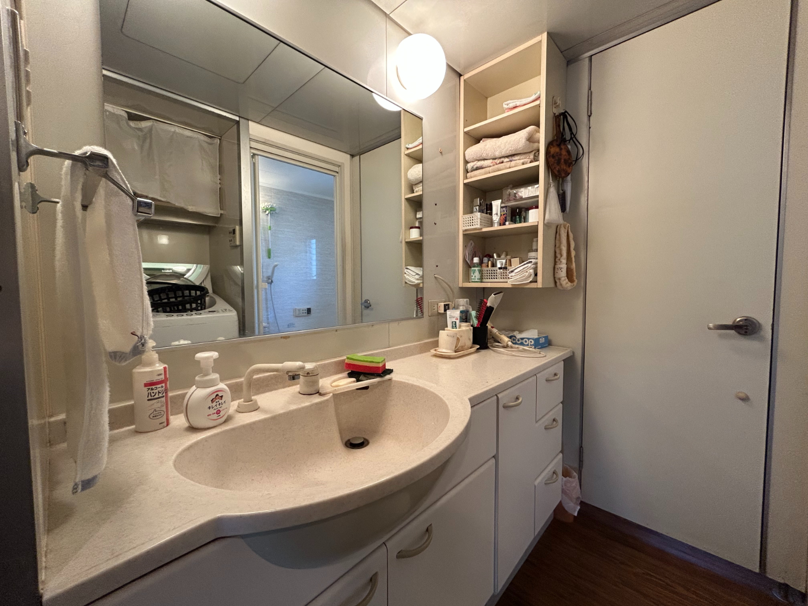 【洗面所】大きな鏡付きの洗面化粧台が設置されています。カウンター部分が広く、快適に利用できます。