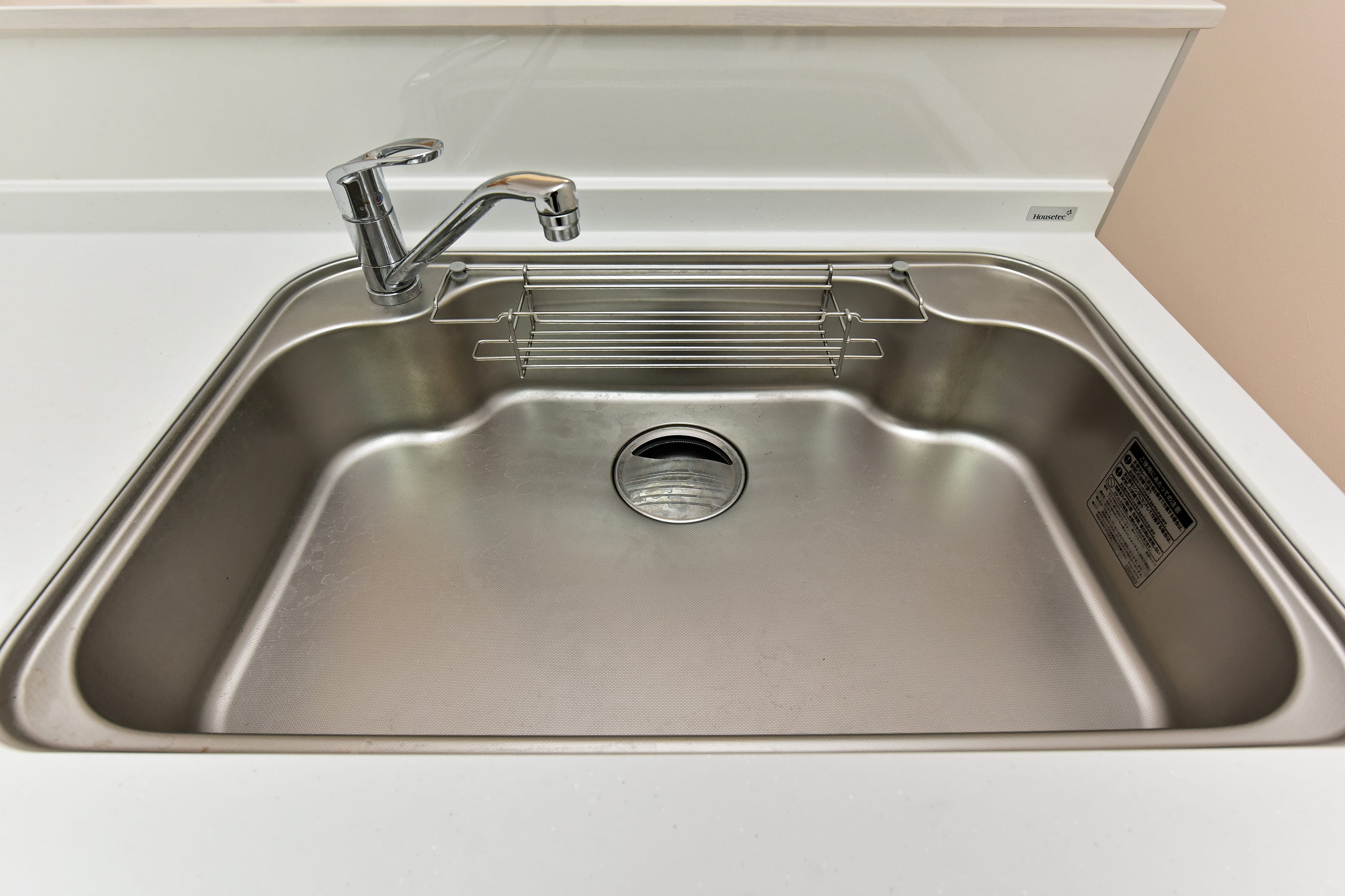 【シンク】キッチンにはワイドシンクが設置されています。カウンターとの段差を少なくした形状で、お手入れがしやすく衛生的です。洗剤やスポンジをすっきり収納できる、センターポケット付きです。