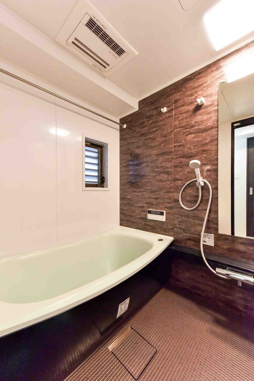 【浴室】木目調のアクセントパネルが施された浴室。便利な浴室換気乾燥暖房機が搭載されており、天候や時間帯を気にせず、いつでも洗濯物を乾かすことができます。