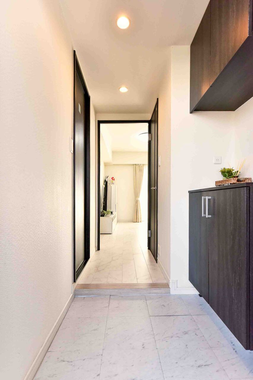 【廊下】廊下の先には明るいLDKが広がり、奥行きを感じられる設計です。廊下やLDKのフローリングと玄関のフロアタイルは、大理石調でコーディネートされています。