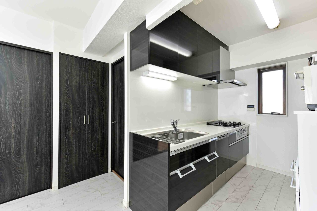 【キッチン】キッチンは、空間を有効に活用できる壁付けタイプ。グリル付きの三口コンロや、食器洗乾燥機などが搭載されています。上下の収納スペースに加え、パントリーも設けられています。