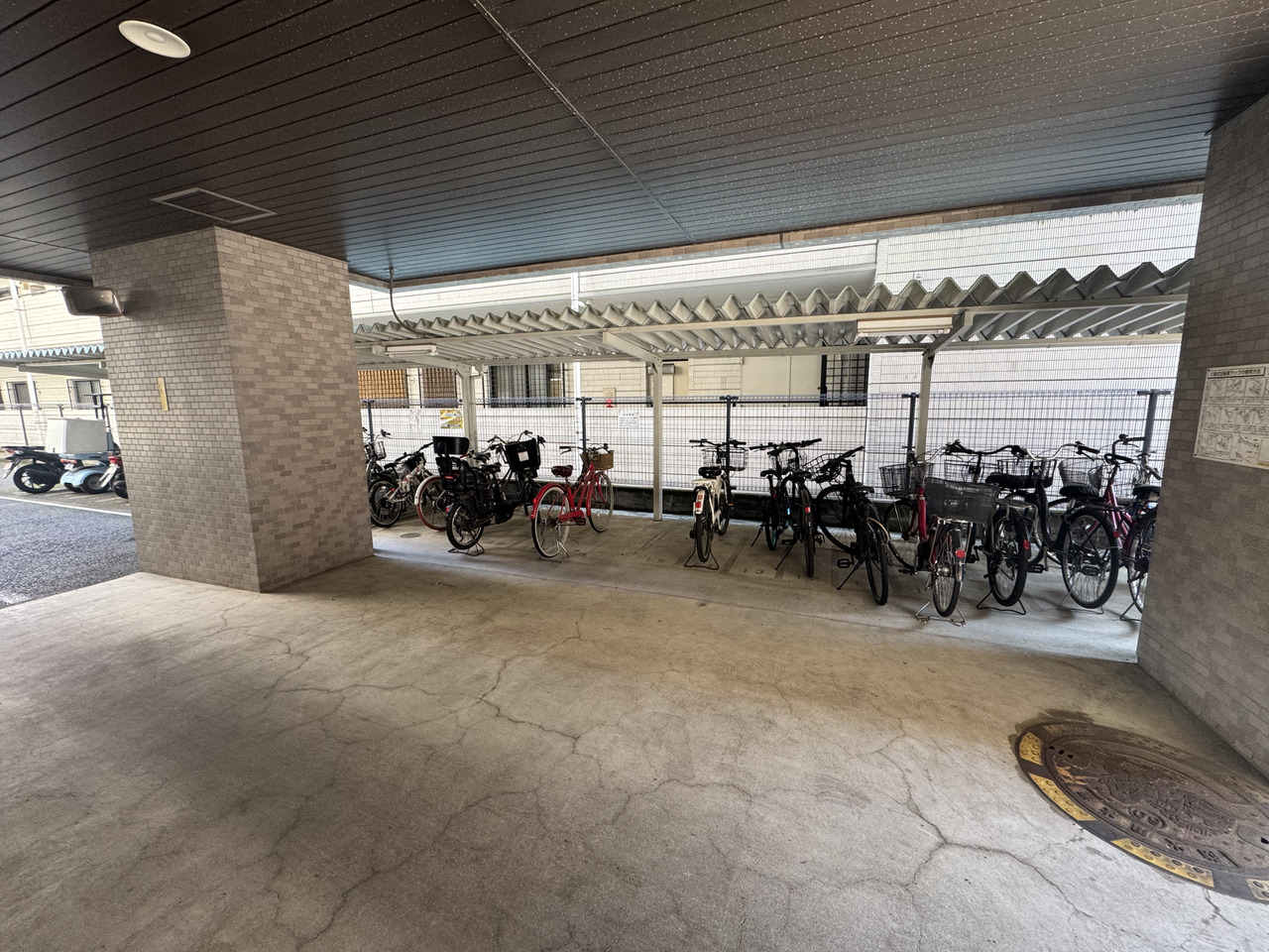 【駐輪場】マンション敷地内にある、大きな屋根で覆われた駐輪場。雨の日でも自転車が濡れにくい構造です。