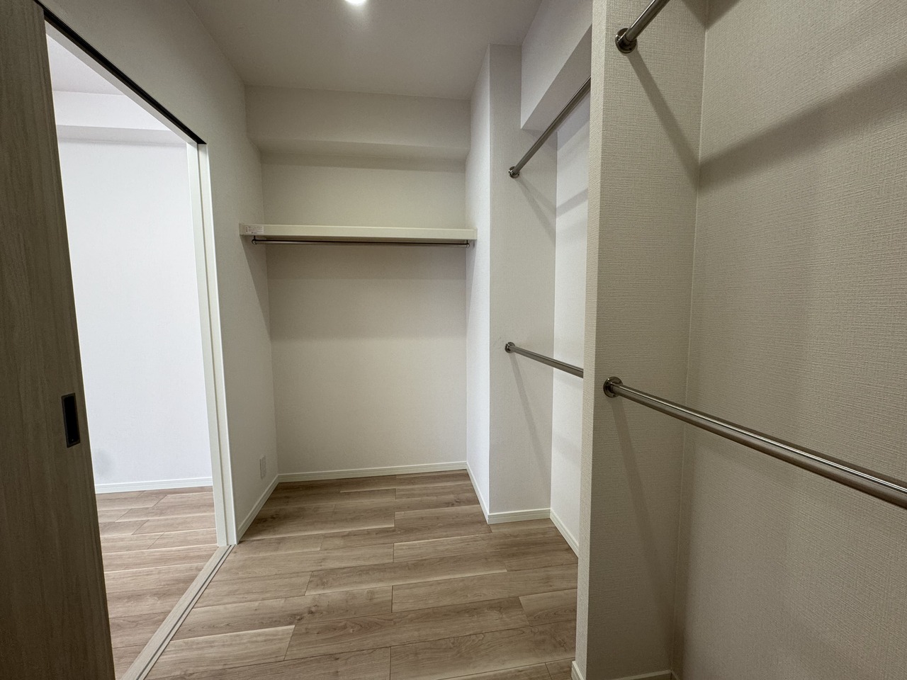 【WIC】枕棚・2段のハンガーパイプが備わり、たくさんの洋服を吊るして収納可能。ご家族みなさまでシェアして利用できる広さです。季節家電や布団など、大きな荷物の保管場所としても役立ちます。