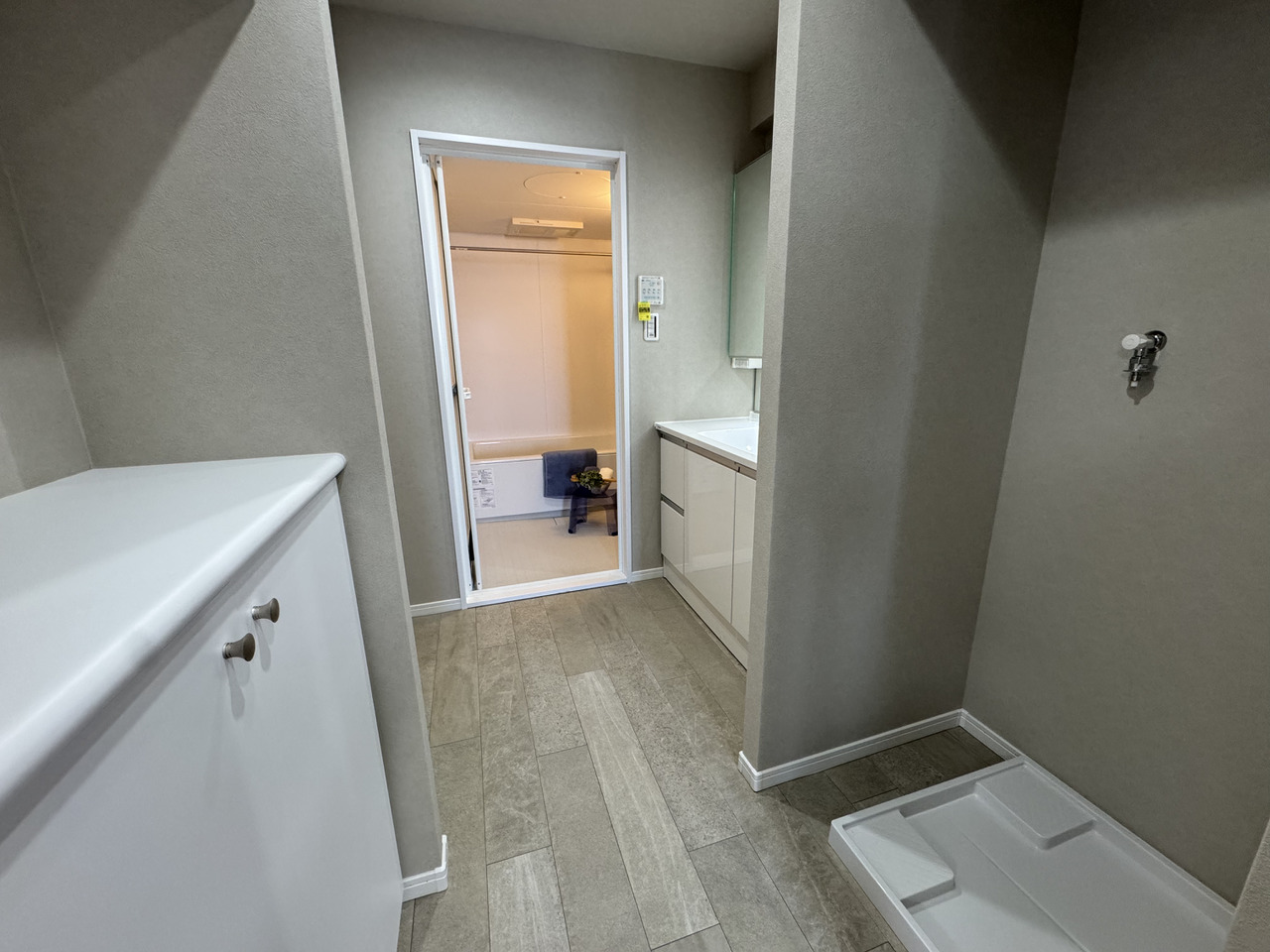 【洗面所】洗面所は廊下とキッチンから出入り可能な2WAY仕様。帰宅後の手洗いや、水回りの家事動線がスムーズです。洗濯機置場の対面に、腰高の収納があります。