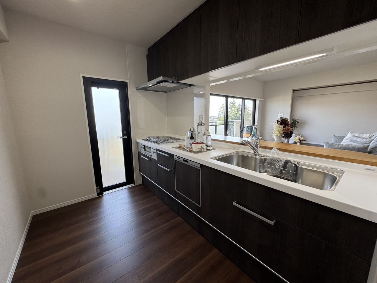 【キッチン】調理中でもご家族との会話が弾む対面式キッチン。食器洗乾燥機が備わっており、食後の片付けが時短になります。勝手口がありバルコニーへと出入りができます。