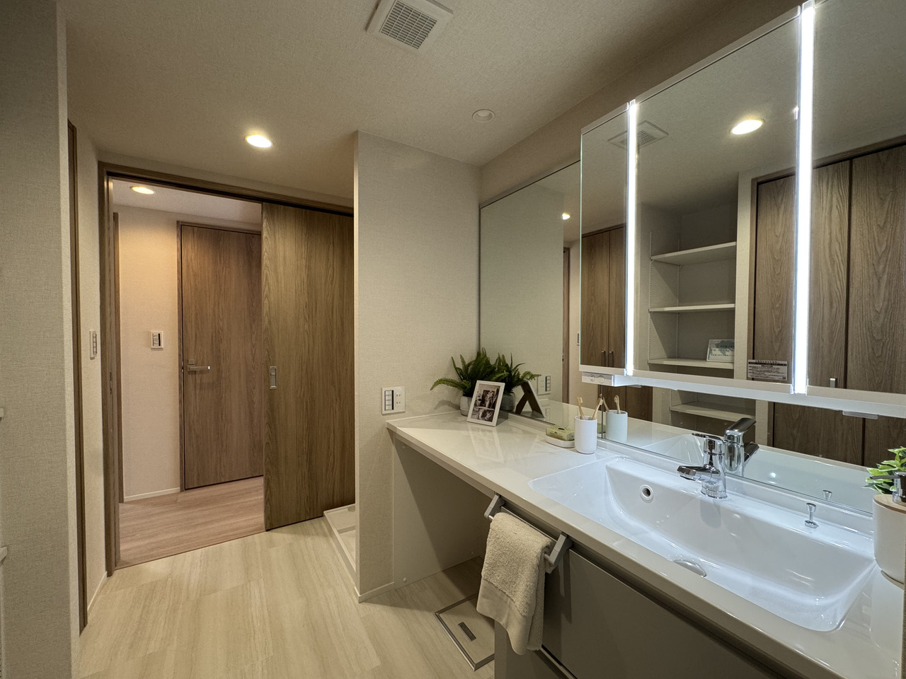 【洗面化粧台】デザイン性と機能性を兼ね備えた、三面鏡付き。ミドルミラー仕様で、小さなお子様も利用しやすいです。サイドにミラーとカウンターがあるため、ヘアセットやメイクの際に重宝します。