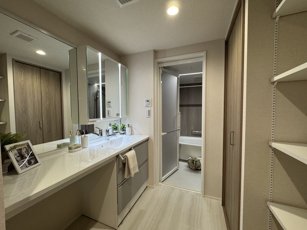 【洗面所】洗面化粧台の収納スペースに加え、扉付きの収納や、可動式棚板付きの収納が設けられています。リネン庫や洗剤類の保管場所として活用可能です。