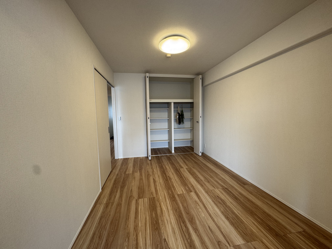 【洋室/約6.0帖】LDK側・廊下側から出入りできる2WAY仕様。端まで物を出し入れしやすい、折れ戸仕様のクローゼットが設けられています。