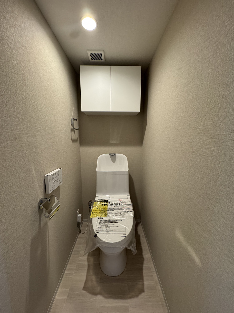 【トイレ】温水洗浄便座付きのため、冬の寒い時期にも冷えを感じにくく、快適に利用できます。上部に吊戸棚があり、予備のトイレットペーパーや掃除道具などを収納可能です。